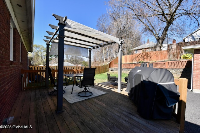 wooden terrace with a fenced backyard, a pergola, grilling area, and outdoor dining space