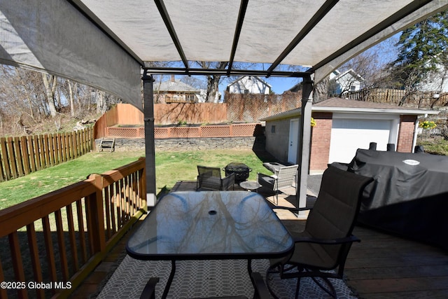 wooden terrace with a yard, outdoor dining area, a fenced backyard, and a garage
