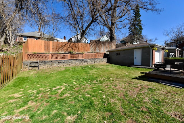 view of yard with an outbuilding, a wooden deck, and a fenced backyard