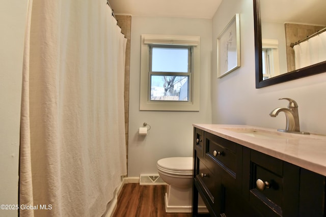bathroom featuring visible vents, wood finished floors, baseboards, vanity, and toilet