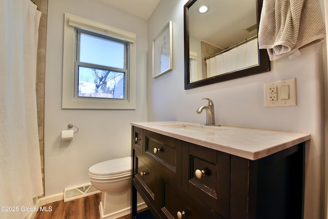 full bathroom featuring vanity, toilet, baseboards, wood finished floors, and visible vents