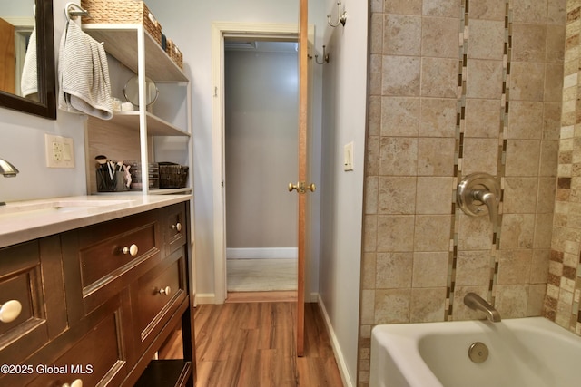 full bathroom featuring baseboards, bathing tub / shower combination, wood finished floors, and vanity