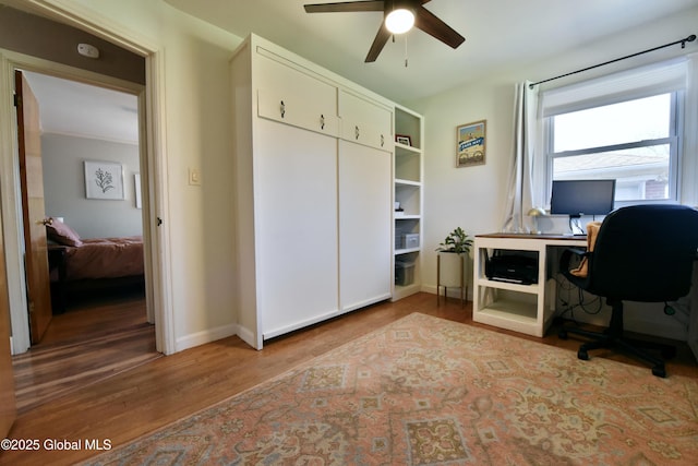 office area with baseboards, a ceiling fan, and wood finished floors