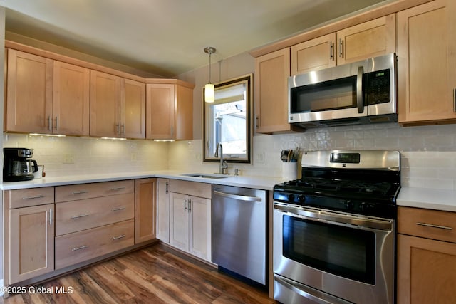 kitchen featuring a sink, appliances with stainless steel finishes, light brown cabinets, and dark wood-style floors
