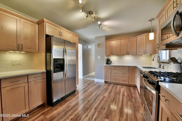 kitchen featuring a sink, light brown cabinets, light countertops, stainless steel appliances, and wood finished floors