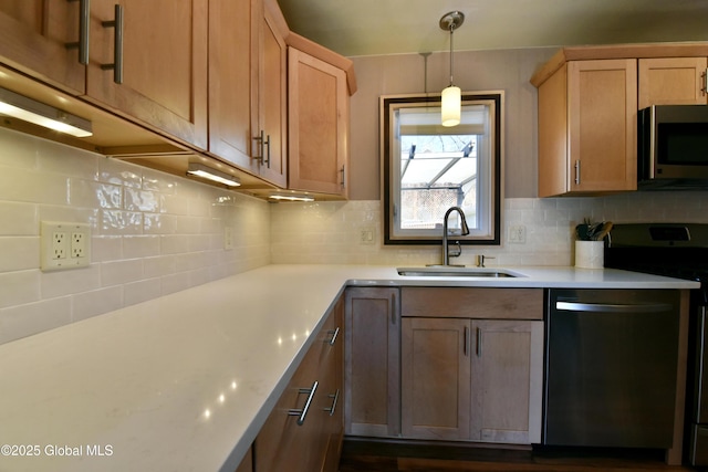 kitchen featuring light countertops, backsplash, appliances with stainless steel finishes, and a sink