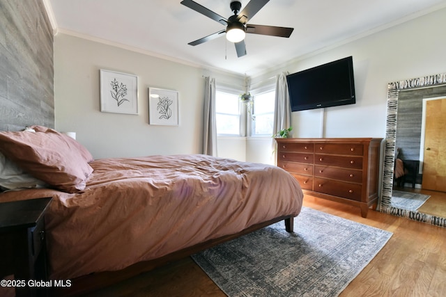 bedroom featuring crown molding, a ceiling fan, and wood finished floors