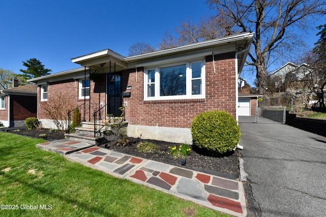 view of front of house featuring fence, a gate, and brick siding