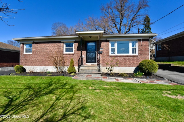 single story home featuring a front yard and brick siding