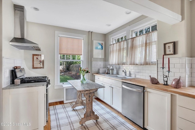 39 5th Ave, Saratoga Springs, NY 12866 - kitchen with appliances with stainless steel finishes, wall chimney range hood, decorative backsplash, and light wood-style flooring