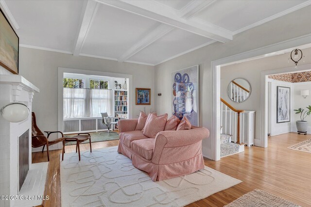 39 5th Ave, Saratoga Springs, NY 12866 - living room featuring a brick fireplace, beam ceiling, light wood-type flooring, crown molding, and stairway