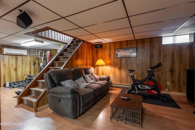 92 Vosburgh Rd, Halfmoon, NY 12118 - living area featuring a wall mounted AC, stairway, a paneled ceiling, wooden walls, and wood finished floors