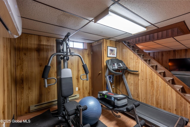 92 Vosburgh Rd, Halfmoon, NY 12118 - workout room featuring a paneled ceiling, wooden walls, and wood finished floors