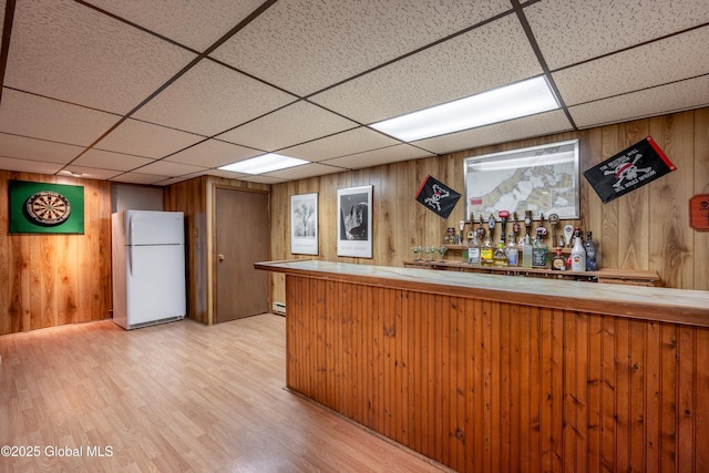 92 Vosburgh Rd, Halfmoon, NY 12118 - indoor dry bar featuring freestanding refrigerator, a paneled ceiling, wooden walls, light wood finished floors, and a baseboard heating unit