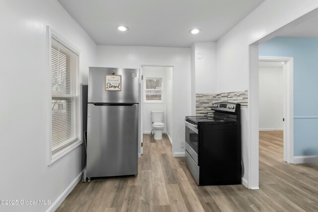 7 Arch Ave, Bethlehem, NY 12203 - kitchen with white cabinetry, baseboards, appliances with stainless steel finishes, and light wood-style floors