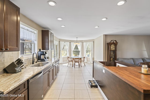 419 Brownell Rd, Malta, NY 12020 - kitchen with tasteful backsplash, light tile patterned flooring, wooden counters, stainless steel dishwasher, and a sink