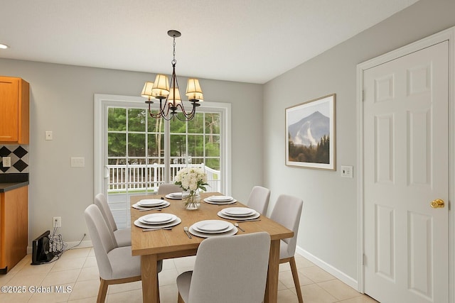 dining area with an inviting chandelier, baseboards, and light tile patterned floors