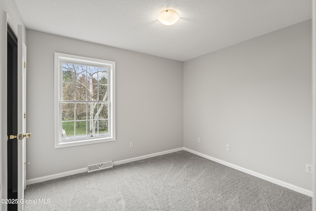 unfurnished room featuring a textured ceiling, baseboards, visible vents, and carpet