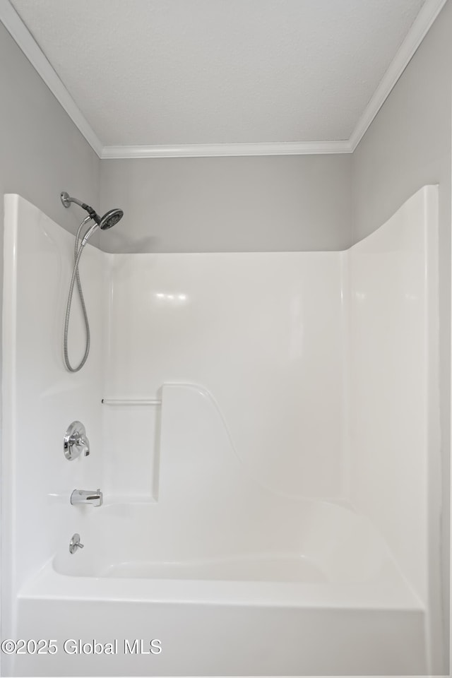 bathroom with crown molding and bathing tub / shower combination
