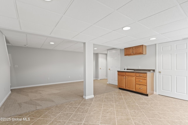 finished below grade area with baseboards, recessed lighting, a drop ceiling, and light colored carpet