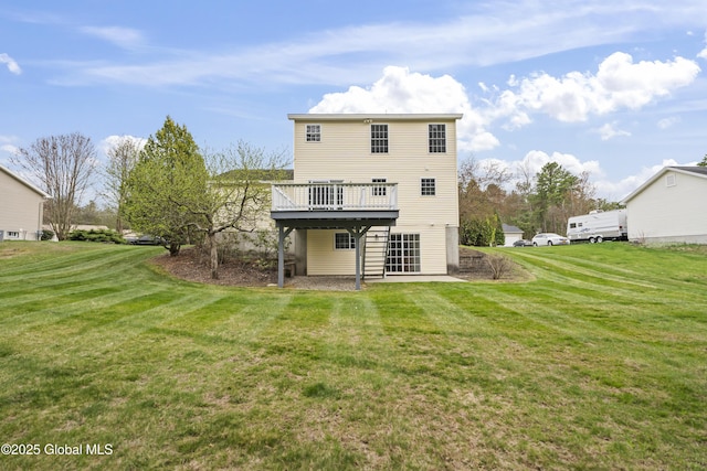 back of property with a yard and a wooden deck