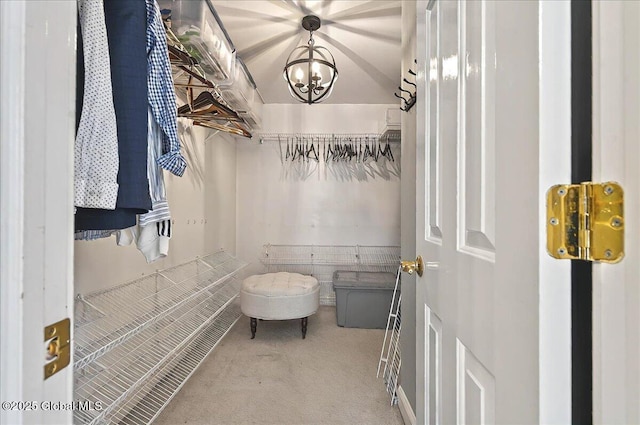 spacious closet with carpet floors and a chandelier