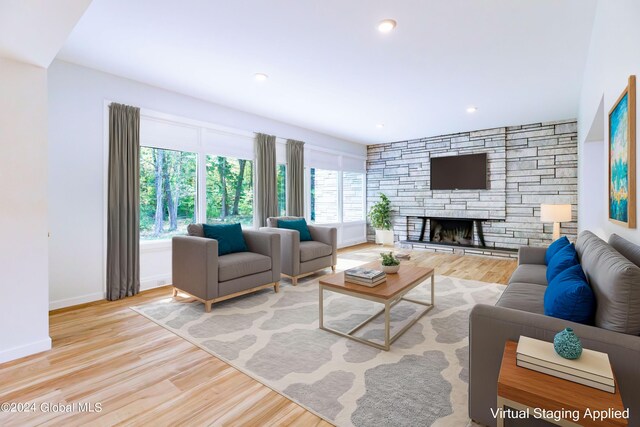 living area featuring recessed lighting, a fireplace, baseboards, and wood finished floors