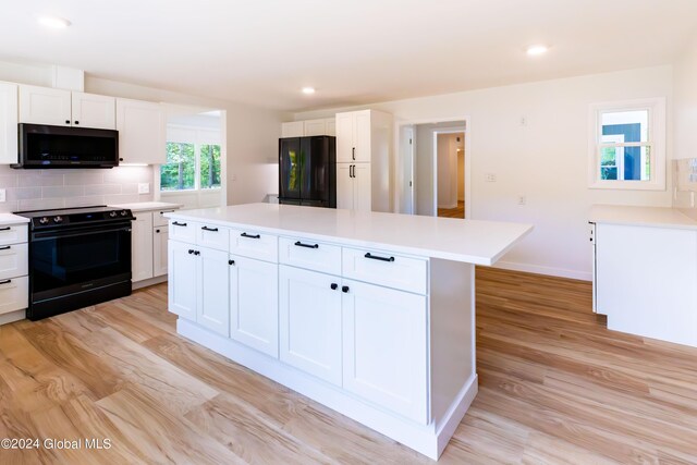 kitchen featuring light wood-type flooring, white cabinetry, and black appliances