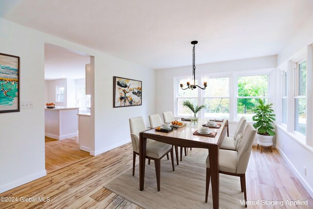 dining space featuring a notable chandelier, light wood-type flooring, and baseboards
