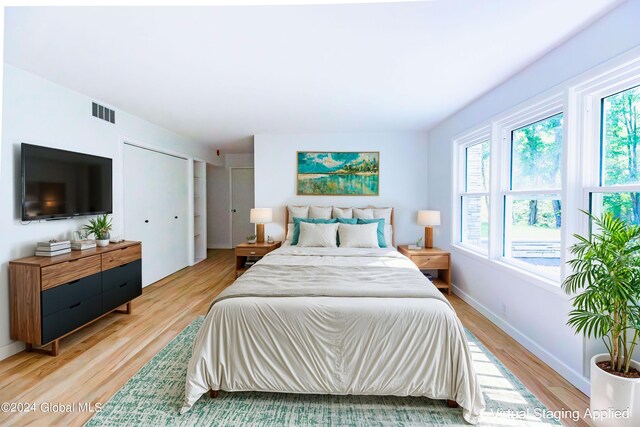 bedroom with light wood-type flooring, baseboards, and visible vents