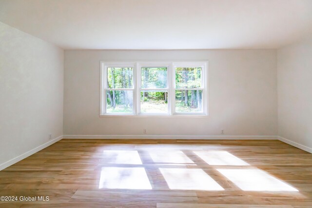 spare room featuring baseboards and light wood-type flooring
