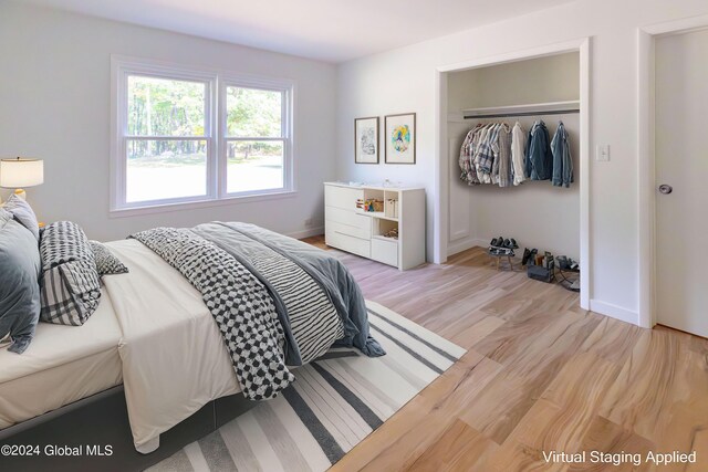 bedroom featuring a closet, light wood-type flooring, and baseboards