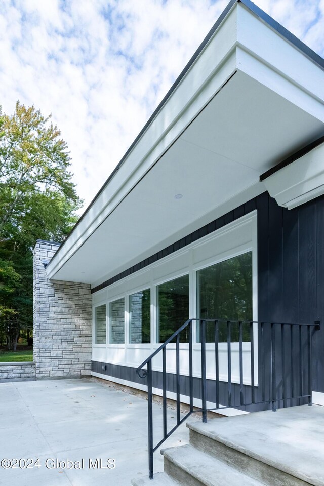 exterior space featuring board and batten siding and stone siding