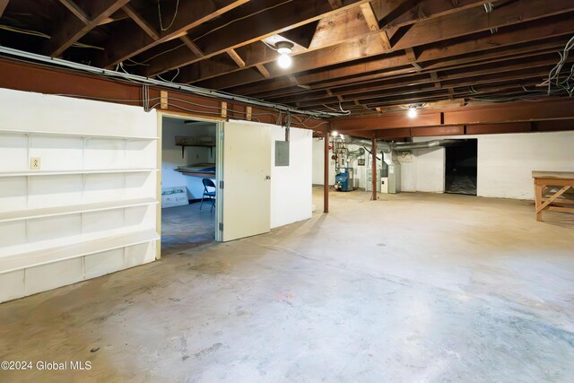 unfinished basement with electric panel and heating unit
