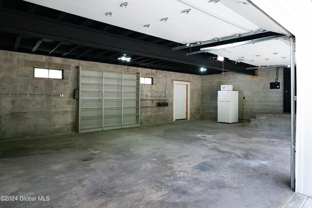 garage with a garage door opener and freestanding refrigerator