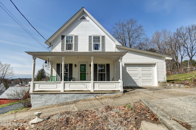 farmhouse with driveway, a porch, and an attached garage