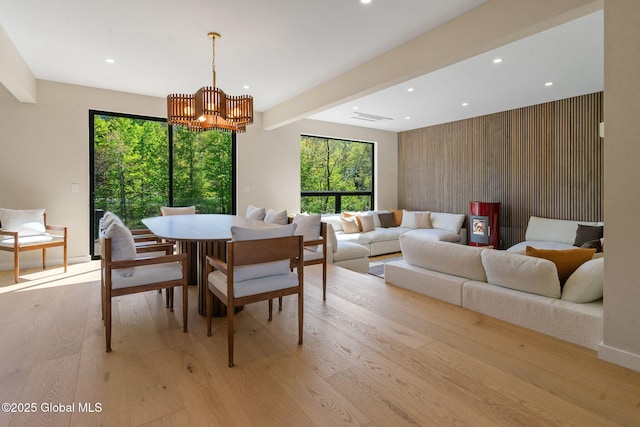 dining room featuring light wood-style floors, a chandelier, recessed lighting, plenty of natural light, and beamed ceiling