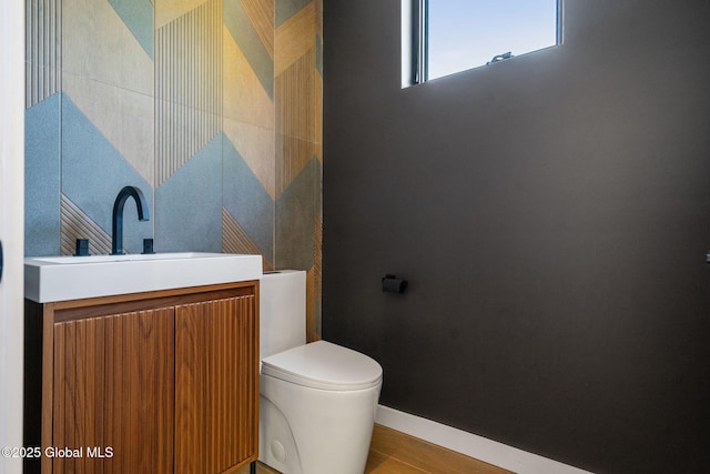 bathroom featuring a sink, toilet, and baseboards