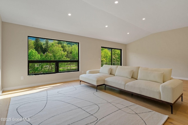 living area with wood finished floors, recessed lighting, vaulted ceiling, and baseboards