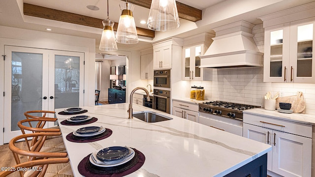 16 Bergen Pl, Niskayuna, NY 12309 - kitchen with custom range hood, tasteful backsplash, light stone countertops, stainless steel gas stovetop, and a sink