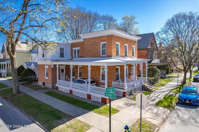view of front of property featuring a porch, crawl space, and brick siding