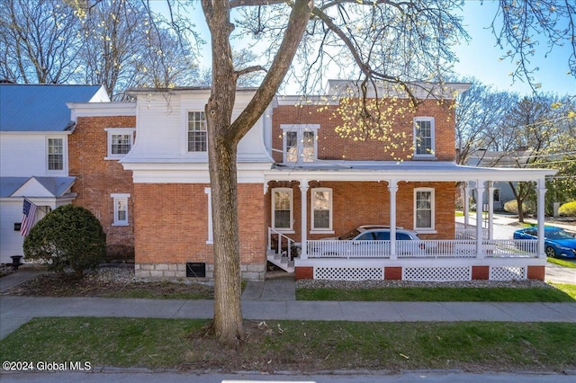 view of front of home with brick siding and a porch