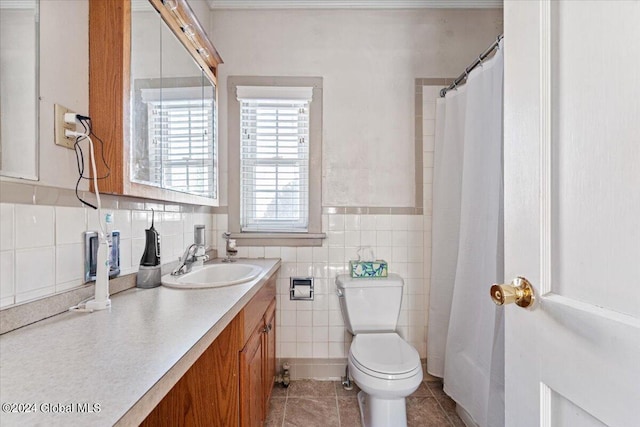 bathroom with toilet, tile walls, tile patterned floors, and vanity