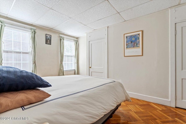 bedroom with baseboards and a drop ceiling