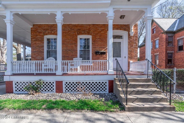 view of front facade with brick siding and a porch