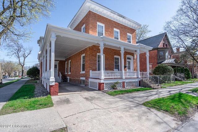 view of front of house with brick siding, a porch, a carport, and concrete driveway