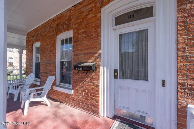 property entrance with brick siding and covered porch