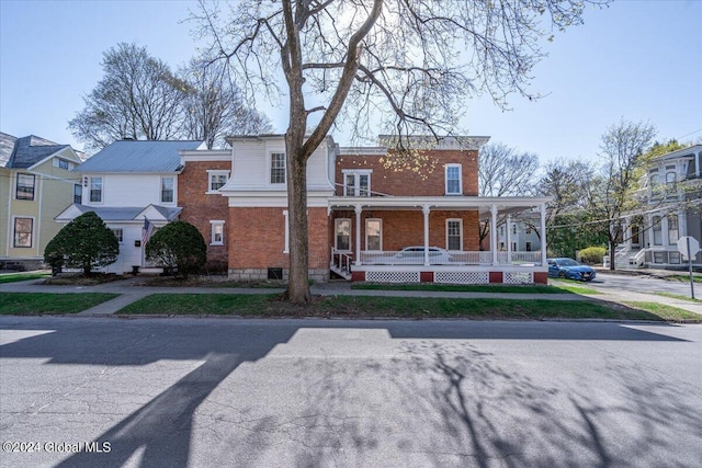 view of front of home featuring a porch and brick siding