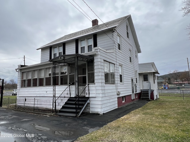 22 Williams St, Whitehall Village, NY 12887 - view of front of home with a chimney, a front yard, a sunroom, entry steps, and fence