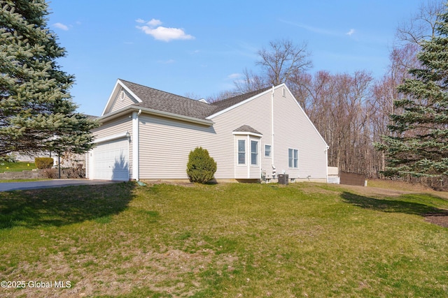 view of home's exterior with a lawn, an attached garage, driveway, and roof with shingles